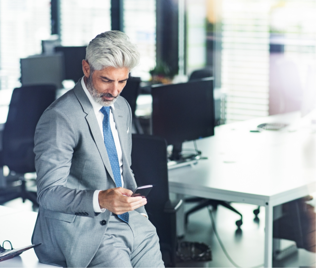 mature businessman with smartphone in the office